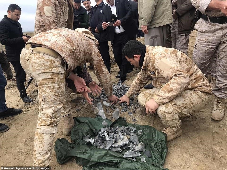 Lực lượng an ninh Iraq dọn các mảnh đạn ở căn cứ không quân Al-Asad sau khi trúng tên lửa trong chiến dịch trả thù cho tướng Soleimani của Iran.