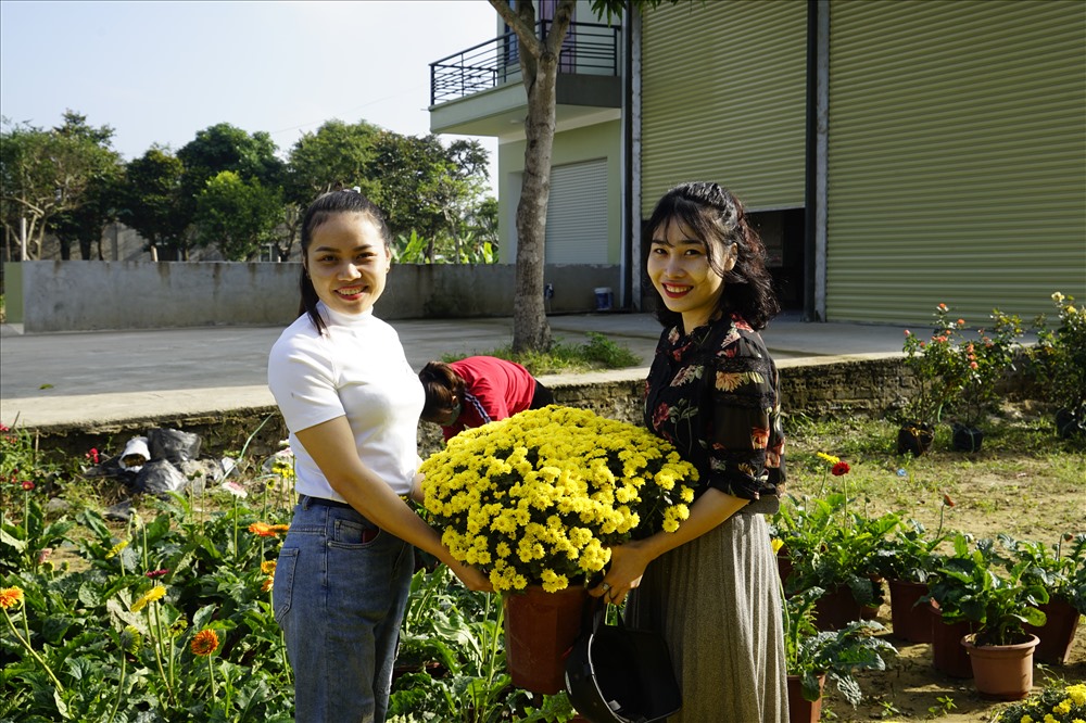 Hai cô giáo mầm non ở TP. Vinh mua hoa về trang trí nhà trường dịp Tết. Ảnh: QĐ