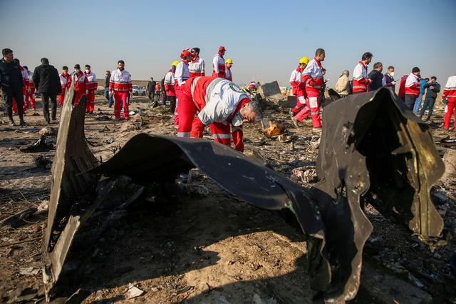 Các công nhân tổ chức Lưỡi liềm đỏ kiểm tra các mảnh vỡ máy bay Ukraina gặp nạn tại hiện trường. Ảnh: West Asia News Agency