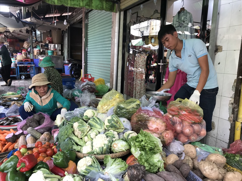 Hàng ngày Tuấn phụ gia đình bán rau ở chợ. Ảnh: Đình Trọng