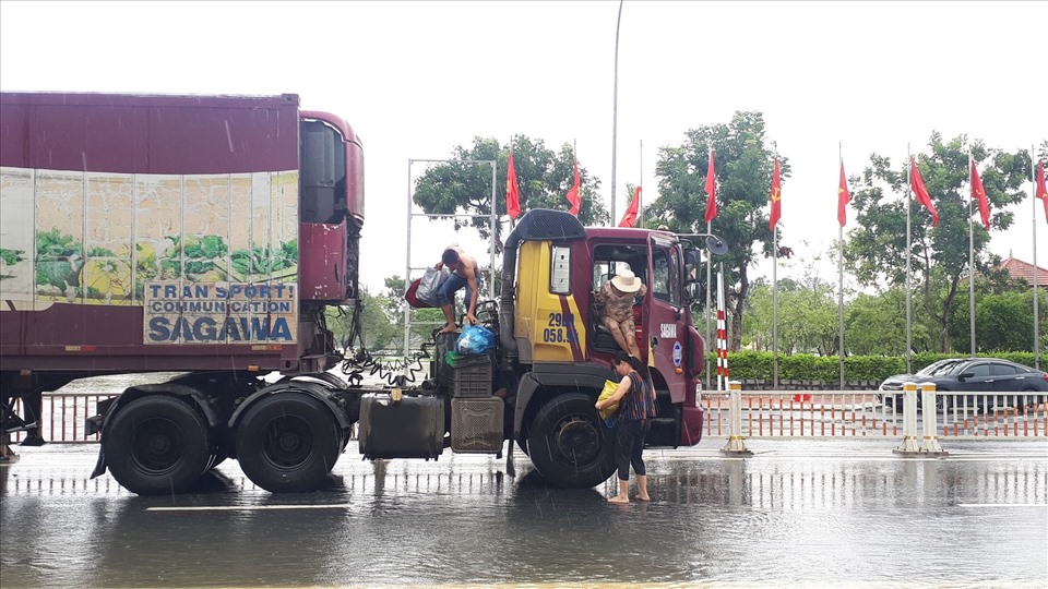 Một người dân xin đi nhờ xe có trọng tải lớn được phép đi qua vùng ngập lụt.