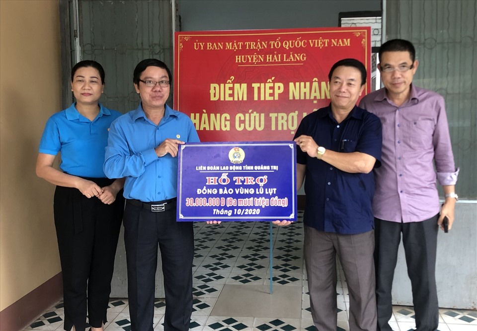 Lãnh đạo LĐLĐ tỉnh Quảng Trị và đại diện Báo Lao Động trao 30 triệu đồng hỗ trợ cho người dân ở vùng rốn lũ Hải Lăng. Ảnh: HT.