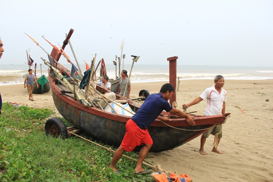 Người dân Sầm Sơn khẩn trương đưa thuyền lên bờ. Ảnh: Q.D