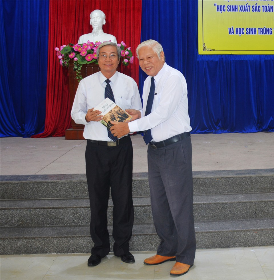 Ông Nguyễn Hữu Xạ (phải) tặng sách cho cán bộ Hội Khuyến học. Ảnh: NVCC