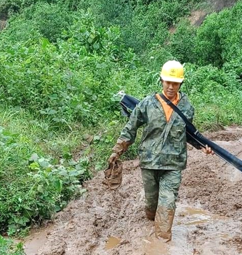 Người lao động Công ty điện lực Quảng Nam băng rừng, lội bùn đi khắc phục sự cố. Ảnh: PCQN