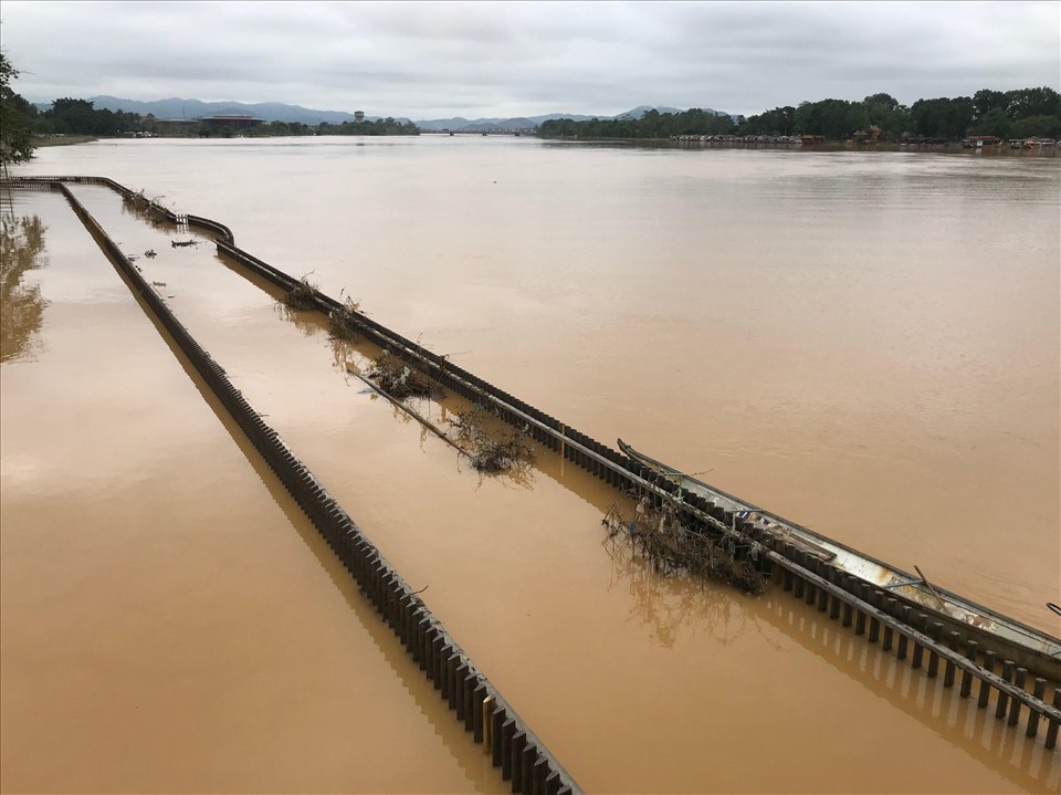 Dù nước vẫn còn ngập, chưa thấy được sàn cầu, nhưng qua kiểm tra sơ bộ dọc tuyến, anh Nguyễn Văn Minh cho biết mặt sàn cầu vẫn an toàn, không có dấu hiệu bong tróc. Ảnh: Tường Minh
