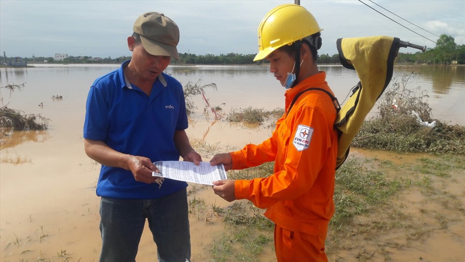 Công nhân Công ty Điện lực Quảng Trị gửi tờ rơi khuyến cáo khách hàng sử dụng điện an toàn sau lũ lụt