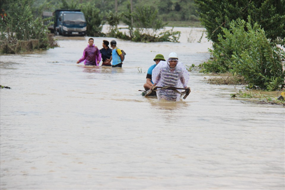 Nước ngập sâu người dân lấy xe kéo xe máy qua dòng nước lũ để về nhà.