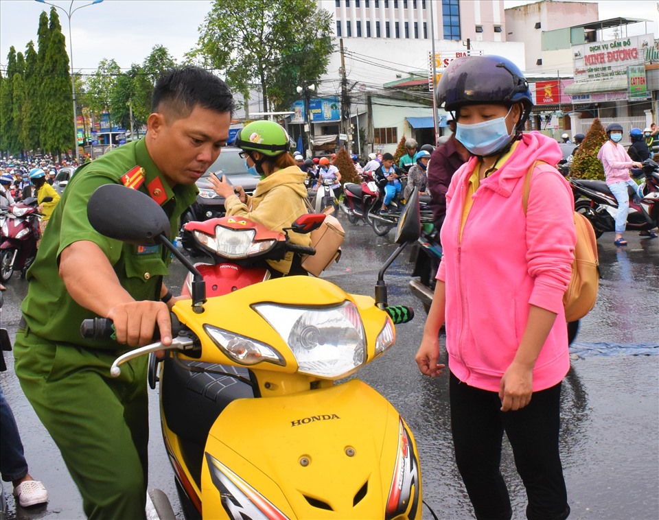 Nhiều xe chết máy do nước ngập trên đường Nguyễn Văn Cừ (quận Ninh Kiều), Công an phường An Khánh giúp người dân sửa xe. Ảnh: Thành Nhân