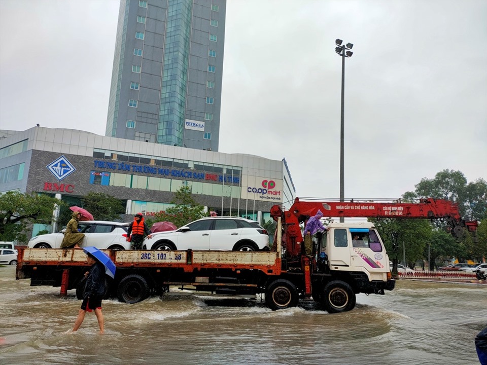 Một số chiếc xe ô tô cỡ nhỏ không thể di chuyển và phải chuyên chở ra khỏi vùng ngập lụt. Ảnh: Quách Du