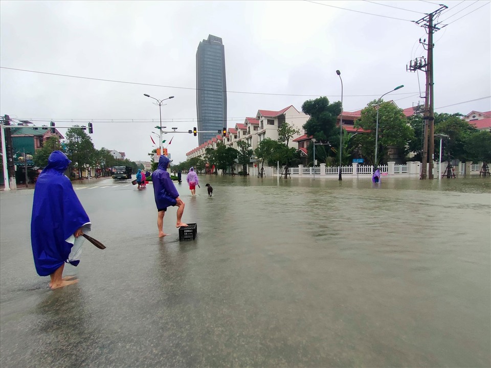 Mang các vật dụng như bu úp gà, rổ, chậu ra bắt cá trên đường phố. Ảnh: Quách Du