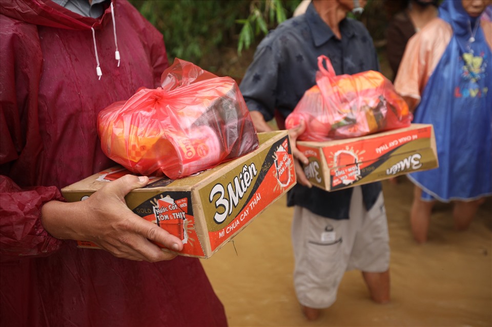 Hình ảnh các thành viên trong nhóm “những bước chân xanh” đến tận nhà trao mì tôm, nước uống cho các hộ dân ở xã Đại Cường bị cô lập do mưa bão.