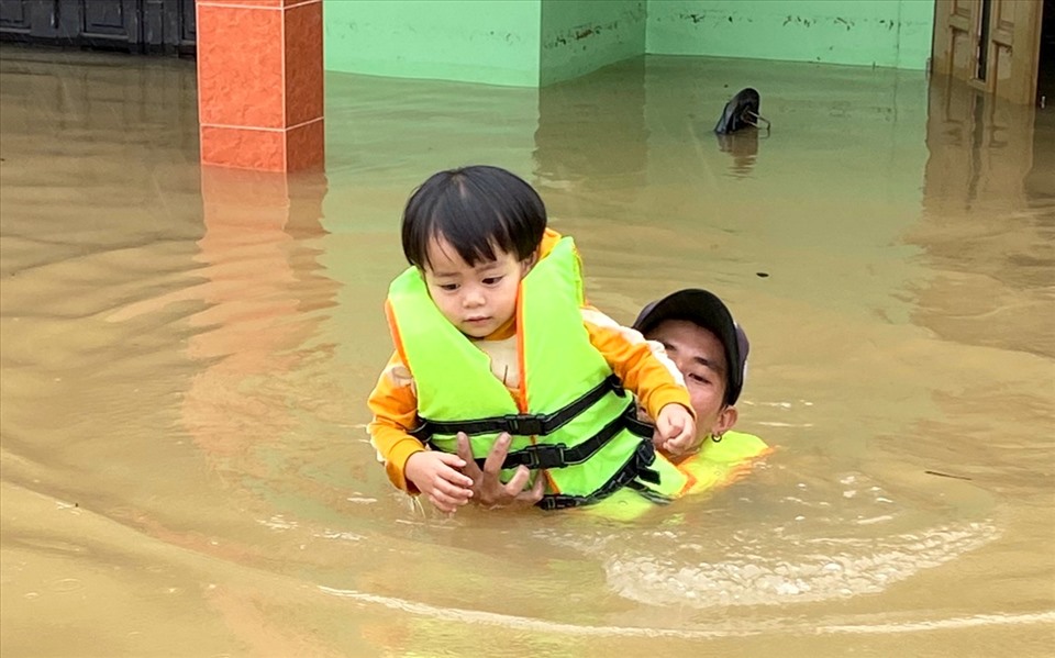Một cháu bé được người dân xã biển Hải Ninh ứng cứu trong cơn lũ. Ảnh: LPL
