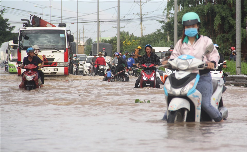 Ghi nhận tại QL1 qua thị xã Bình Minh, huyện Tam Bình (tỉnh Vĩnh Long), từ 6h30 sáng, triều cường gây ngập khiến việc đi lại của người dân gặp nhiều khó khăn.