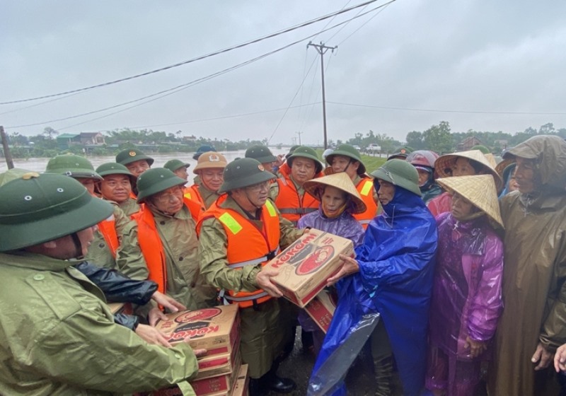 Phó Thủ tướng Trịnh Đình Dũng trao quà, nhu yếu phẩm cho bà con trong vùng lũ huyện Cẩm Xuyên. Ảnh: BHT