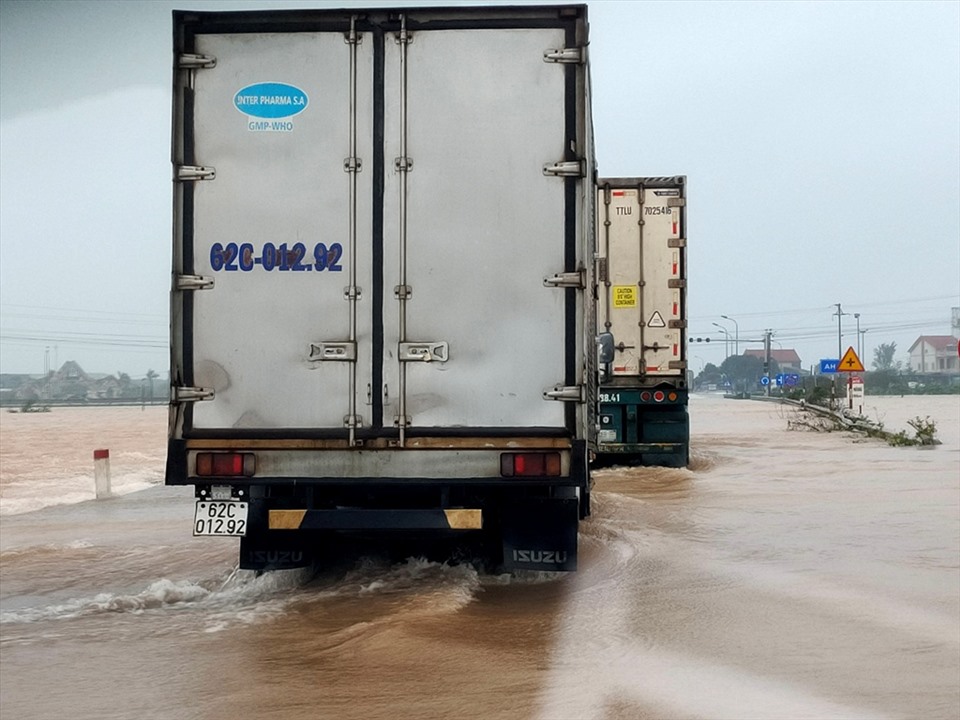 Các loại xe khách, xe tải đường dài được phép qua đoạn đường ngập lụt. Riêng xe con và các phương tiện cỡ nhỏ chưa được phép. Ảnh: Quách Du