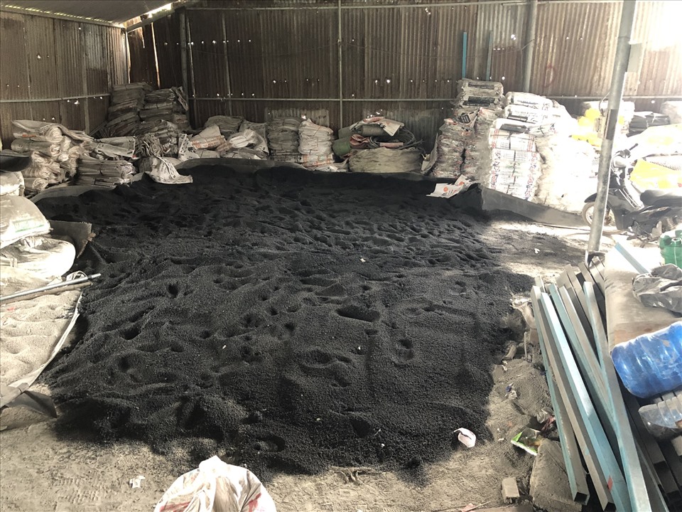Hàng tấn phân bón màu đen được đổ xuống nền nhà và chưa đóng bao. Ảnh: DMS