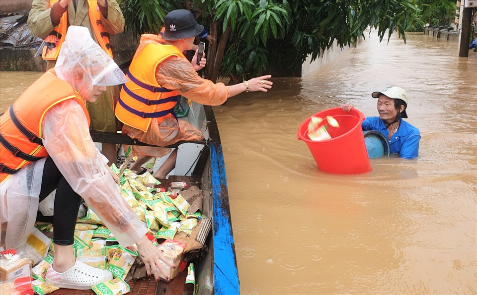 Người dân huyện Lệ Thủy vượt nước lũ ra nhận hàng cứu trợ. Ảnh: LPL