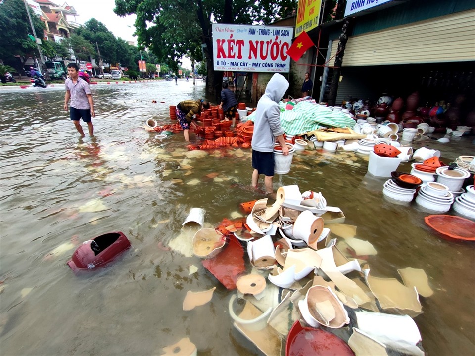Một hộ dân kinh doanh trên đường Hà Huy Tập, TP. Hà Tĩnh dọn dẹp sau khi nước lũ rút. Ảnh: Quách Du