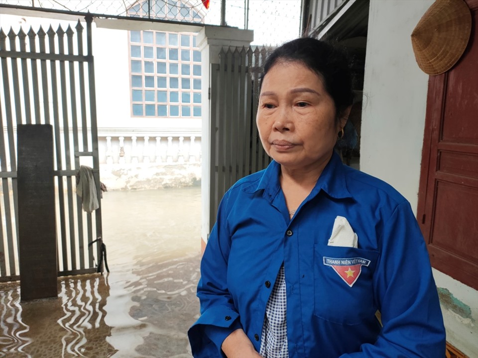 Bà Lê Thị Mai Hoa trở về nhà của mình để dọn dẹp sau 3 ngày tránh lũ ở nhà hàng xóm. Ảnh: Quách Du