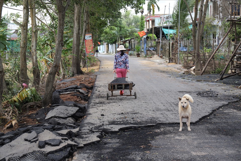 Một số người dân tận dụng những mảng đường hư hỏng nhặt đường về nhà kè đất đá. Ảnh: Hữu Long