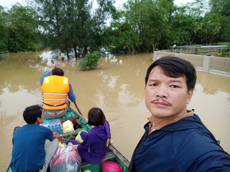 Thầy Nguyễn Quốc Hiệp đi thuyền cứu trợ người dân vùng lũ lụt. Ảnh: Quốc Nam