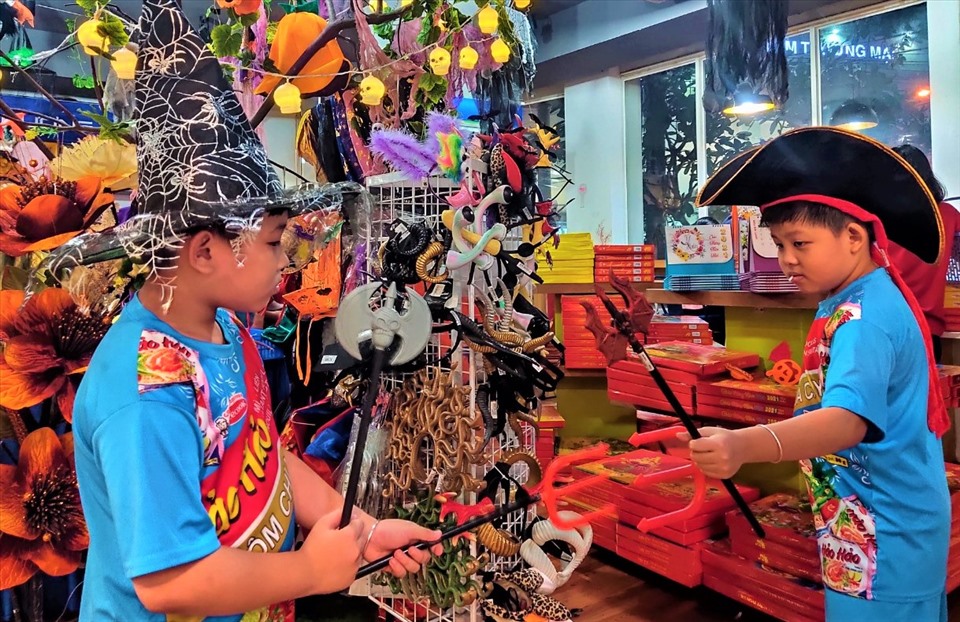 2 bé trai háo hứng với dụng cụ và nón tai cửa hàng nhà sách Phương Nam.