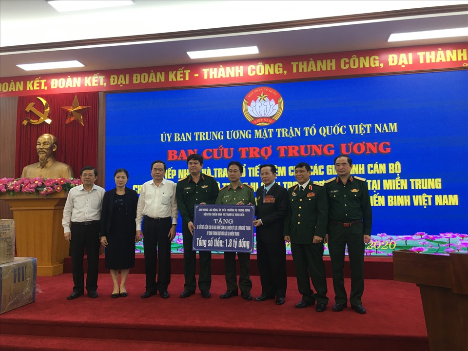Anh hùng Lao động, Uỷ viên thường vụ Trung ương Hội Cựu chiến binh Việt Nam Lê Văn Kiểm (thứ 3 từ phải sang) trao tặng 36 sổ tiết kiệm cho 36 gia đình cán bộ, chiến sĩ lực lượng vũ trang đã hy sinh trong đợt mưa lũ tại miền Trung. Ảnh: Hải Anh