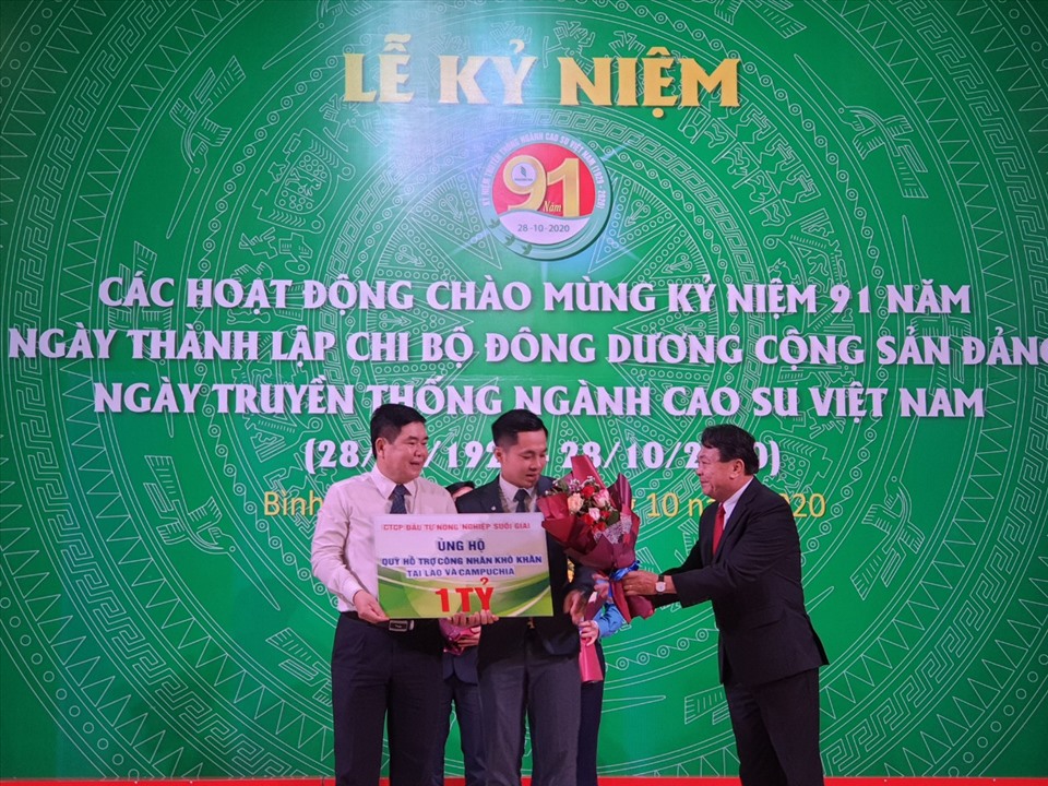 Ông Phan Mạnh Hùng (bìa phải) Chủ tịch Công đoàn Caosu Việt Nam tặng hoa cám ơn các đơn vị ủng hộ xây dựng Làng Công nhân Caosu. Ảnh Nam Dương
