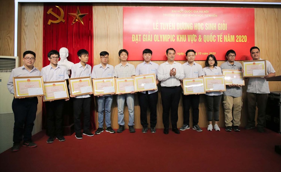 PGS.TS. Phạm Bảo Sơn, Phó Giám đốc Đại học Quốc gia Hà Nội (thứ 5 từ phải sang) trao bằng khen và phần thưởng cho các em học sinh có thành tích xuất sắc trong kỳ thi Olympic quốc tế năm 2020. Ảnh: NTCC.