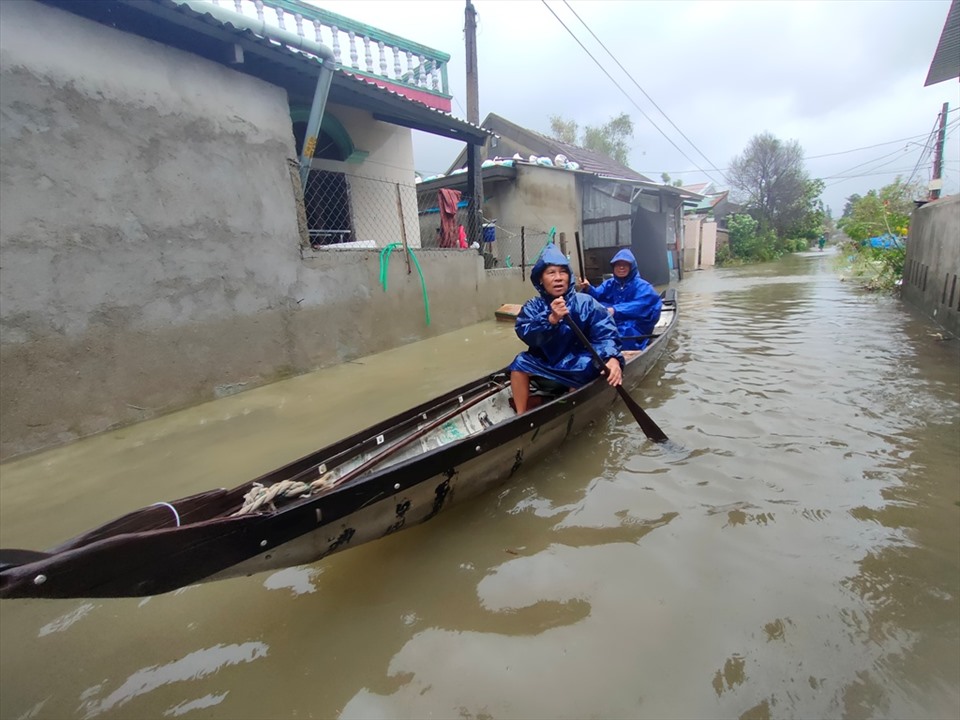 Những đợt sóng lơn ập vào nhà, khiến các hộ dân tại khu phố 4, thị trấn Phú Lộc phải lội giữa dòng nước và di chuyển bằng thuyền. Ảnh: Q.D