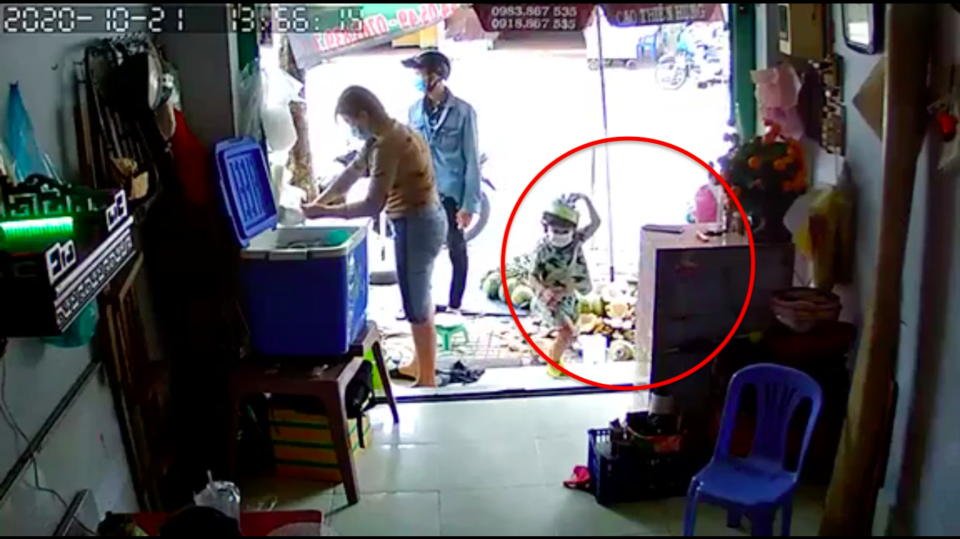 Dưới sự xúi giục của nam thanh niên đi cùng, bé trai đã trộm điện thoại của người bán dừa vào ngày 21.10 tại TPHCM. Ảnh: Trích xuất từ camera an ninh