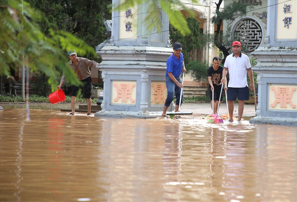Người dân ở thị xã Quảng Trị cào bùn sau khi nước lũ rút. Ảnh: Hưng Thơ.