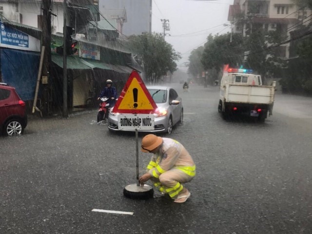 CSGT thành phố Hà Tĩnh cắm biển báo đường ngập. Ảnh: CA.