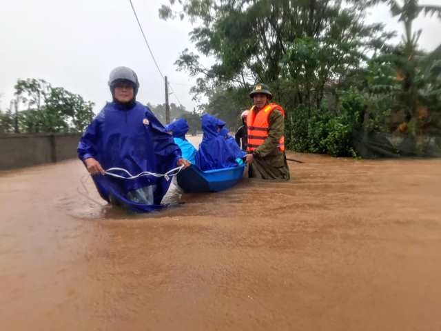 Công an huyện Thạch Hà dùng thuyền sơ tán dân khỏi vùng ngập lụt. Ảnh: TH.