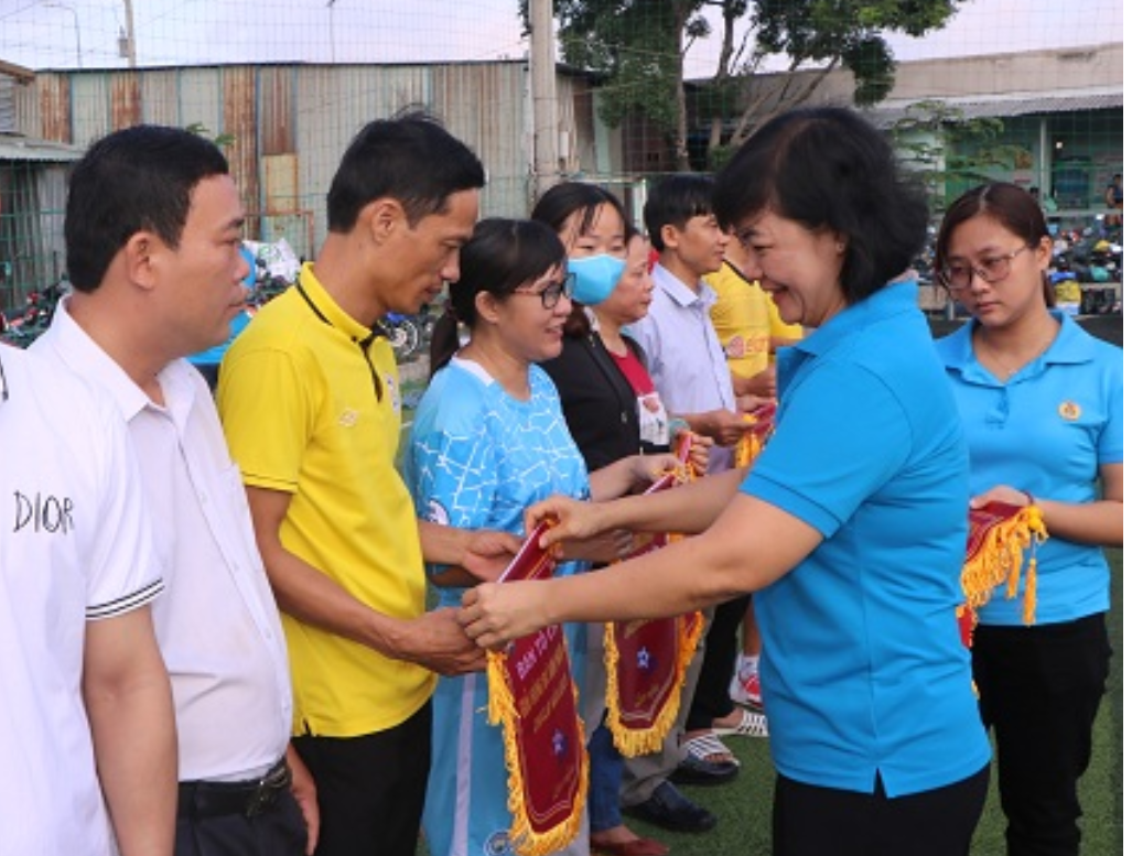 Bà Nguyễn Thị Hồng Trang - Phó ban Tuyên giáo Nữ công, LĐLĐ tỉnh Bình Dương trao cờ lưu niệm cho các đội bóng. Ảnh: Khánh Phong