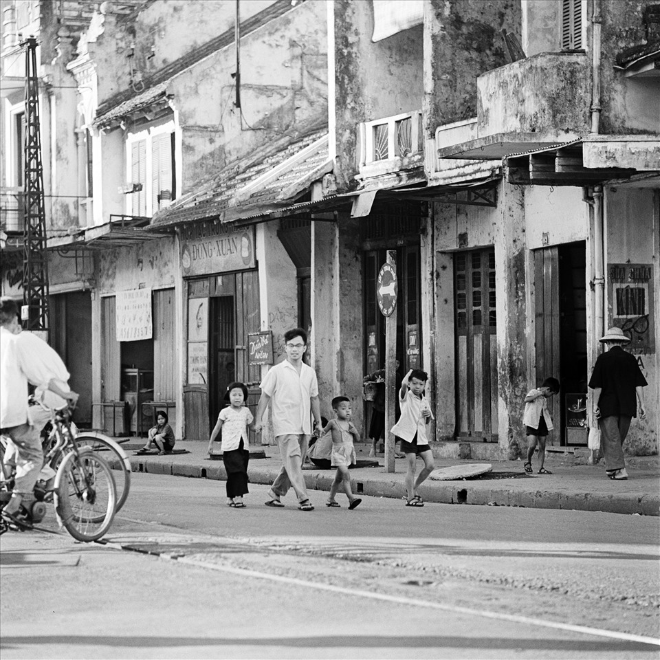 “Hà Nội 1967-1975” qua ống kính của Thomas là niềm vui đón đứa trẻ chào đời trong chiến tranh, là những hầm tránh bom chằng chịt trên hè phố, là những phố xá vắng bóng người, là những dáng người lầm lụi trong mưa...