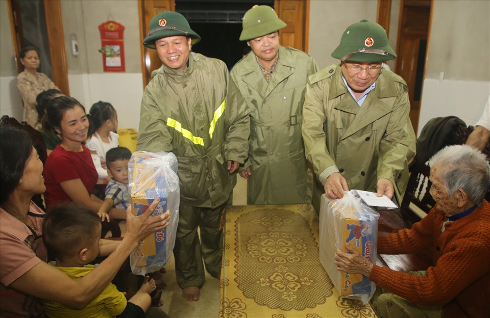 Những người dân chạy lũ, hiện đang trú tại nhà ông Hoàng Hiền được lãnh đạo UBND tỉnh Quảng Trị tặng quà. Ảnh: Hưng Thơ.