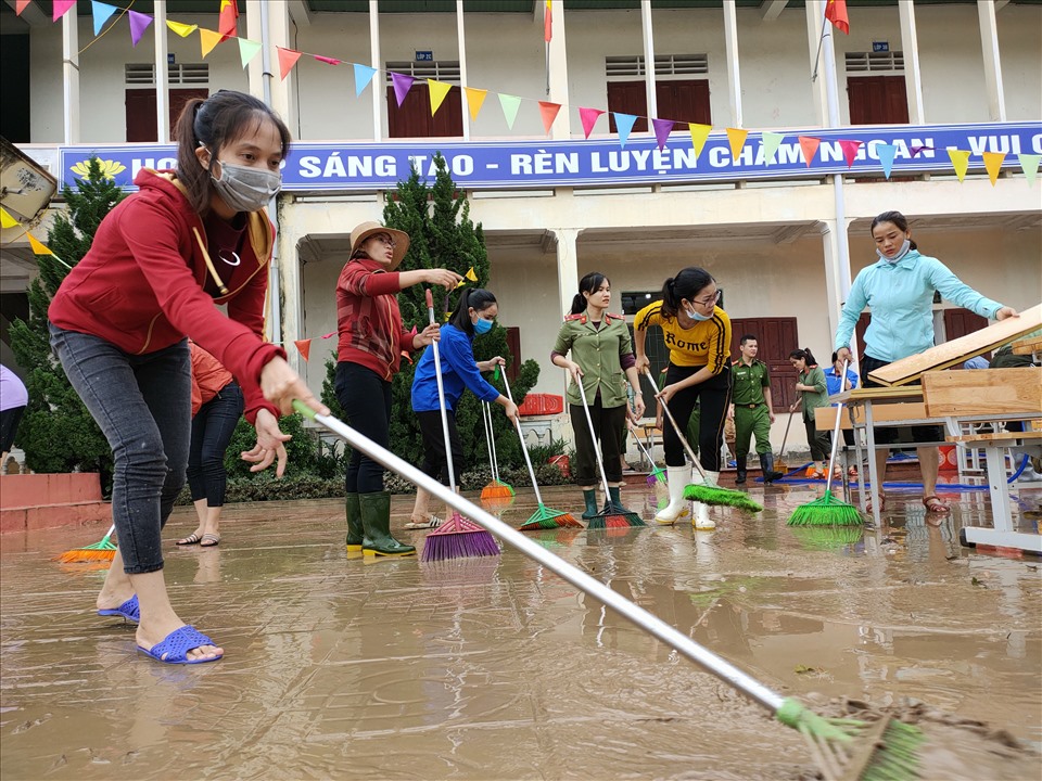Các cô giáo trường Tiểu học Nghi Phương, huyện Nghi Lộc hăng say don dẹp vệ sinh sau khi trường bị ngập nặng. Ảnh: Quang Đại