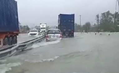 Đoạn đường QL1A đi qua xã Lộc Trì (huyện Phú Lộc) nước lũ tràn qua hơn 40cm gây khó khăn cho các phương tiện giao thông. Ảnh: PV.