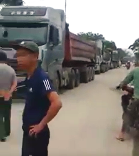 Người dân chặn đoàn xe tải chở vật liệu vào Nhà máy ximăng Hướng Dương. Ảnh: NT