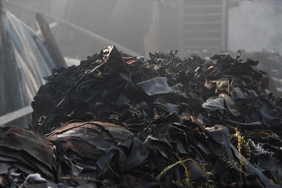 Xung quanh nhà kho bị cháy có nhiều rác thải là các bao tay da. Ảnh: Đình Trọng
