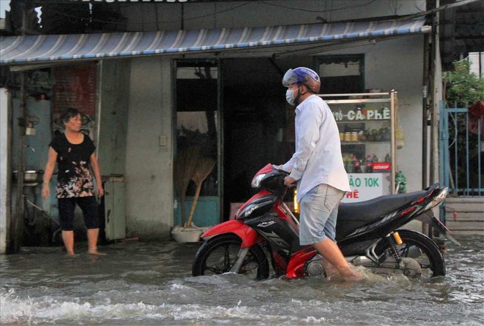 Tại đường Trần Xuân Soạn, Q.7, nước ngập gần cả bánh xe máy khiến việc di chuyển của người dân qua đoạn đường này rất khó khăn.