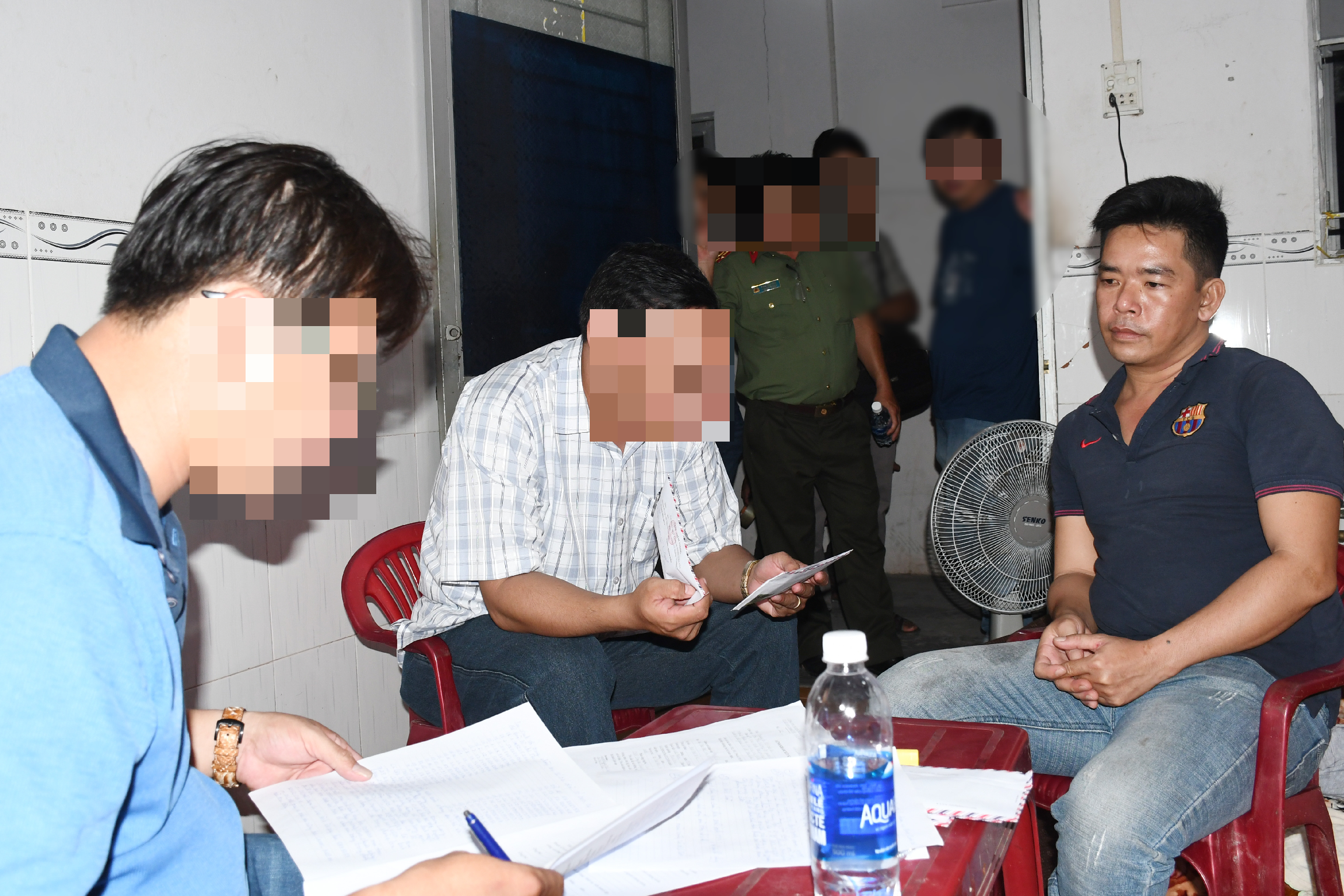 Đối tượng Nguyễn Huỳnh Minh Tâm (áo thun đen, bên phải qua) khi bị bắt giữ. Ảnh: CACC