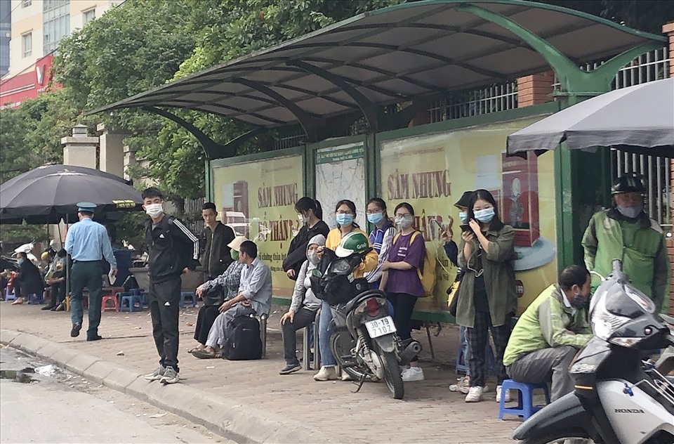 Hầu  hết hành khách tại điểm chờ xe buýt trên đường Phạm Hùng đều đeo khẩu trang. Ảnh K.Anh
