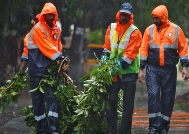 Chính quyền địa phương nỗ lực dọn dẹp cây cối và cột điện bị đổ do bão Nivar. Ảnh: Reuters