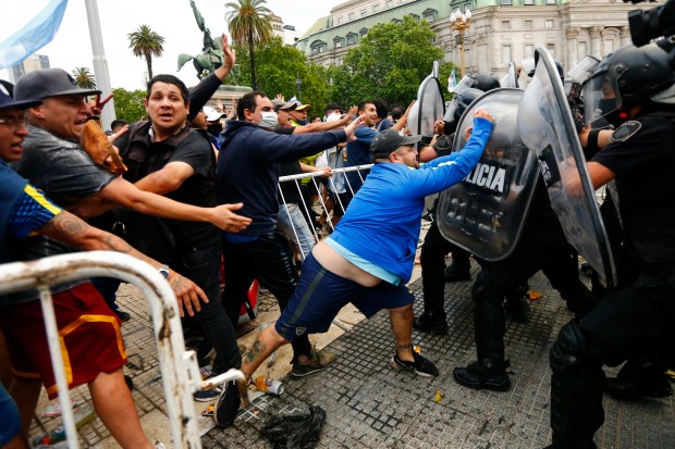 Tình trạng  bạo động xảy ra khi một số người quá khích muốn tiếp cận xe tang của huyền thoại Maradona. Ảnh: AP