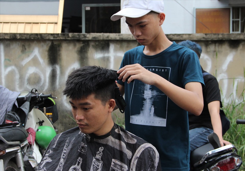 Anh Nguyễn Văn Khang làm thợ hàn trong khu công nghiệp Sóng Thần cũng đến cắt tóc miễn phí khi đi làm về. Ảnh: Đình Trọng