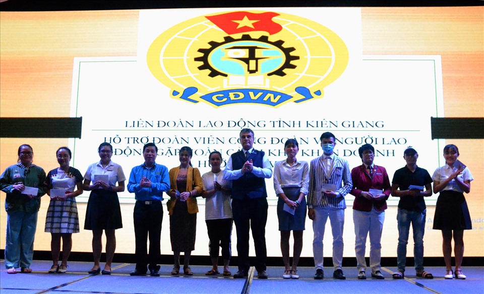 Lãnh đạo doanh nghiệp cùng Chủ tịch LĐLĐ tỉnh Kiên Giang chụp ảnh lưu niệm với đoàn viên được nhận hỗ trợ do ảnh hưởng COVID-19.  Ảnh: Lục Tùng