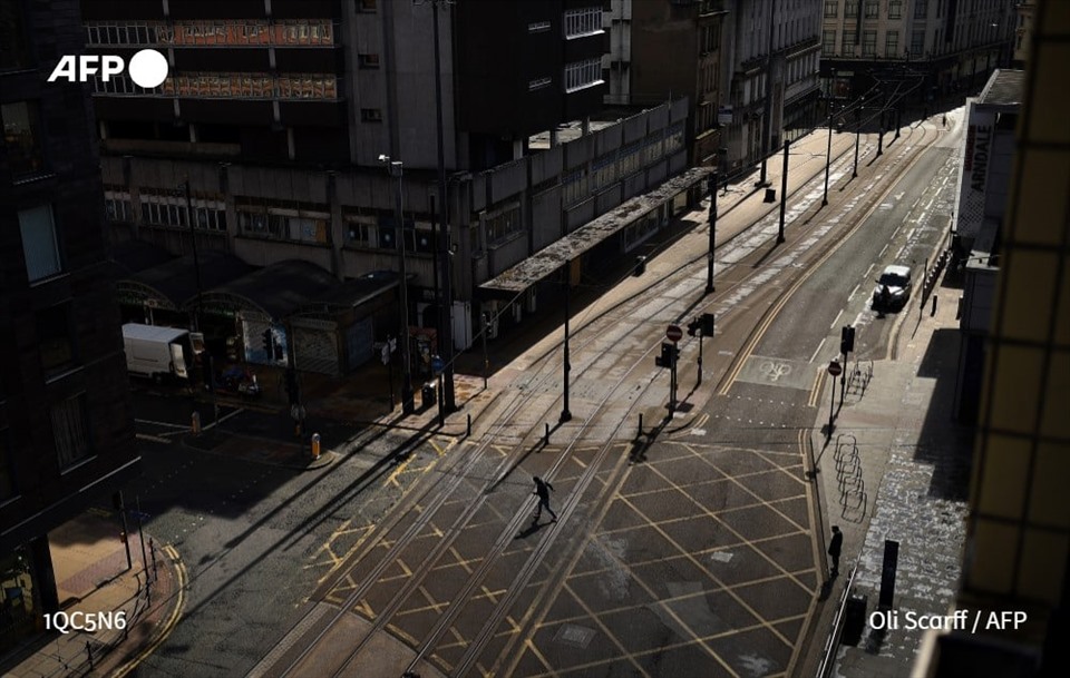 Một người đi bộ đi ngang qua con phố vắng tanh ở Manchester, phía bắc nước Anh hôm 2.4, khi nước này đang trong đợt phong tỏa toàn quốc nhằm ngăn chặn lây lan đại dịch COVID-19. Ảnh: AFP